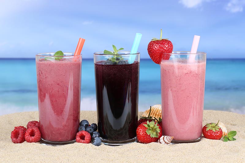 strawberry and blackberry fruit smoothies on the beach